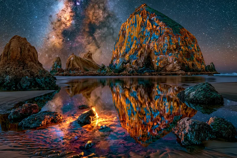 A breathtaking night scene unfolds on a beach, with the Milky Way